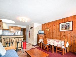 a living room with a table and a kitchen at Apartment Plagne Centre 1 - LAP170 by Interhome in La Plagne