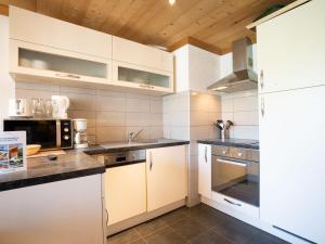 a kitchen with white cabinets and a refrigerator at Apartment Le Lac Blanc-3 by Interhome in Val Thorens