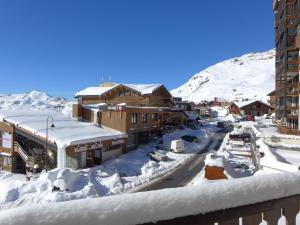 a town covered in snow with buildings and a mountain at Apartment Les Glaciers by Interhome in Val Thorens