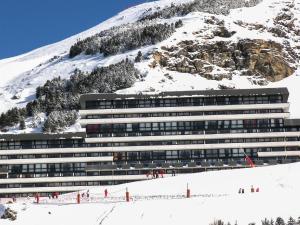 a building in front of a snow covered mountain at Apartment Brelin-8 by Interhome in Les Menuires