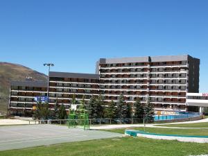 a large building with a tennis court in front of it at Apartment Chavière-5 by Interhome in Les Menuires