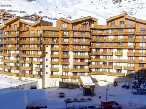 um grande edifício na neve com um parque de estacionamento em Apartment La Roche Blanche-6 by Interhome em Val Thorens