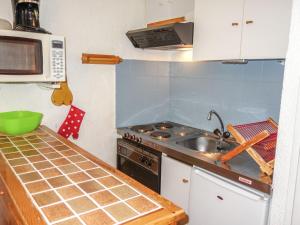 a small kitchen with a sink and a microwave at Apartment Sapin B by Interhome in Demi-Quartier