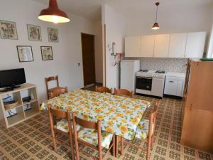 a kitchen with a table and chairs and a kitchen with white appliances at Apartment Villa Martinelli-1 by Interhome in Crone +14 photos