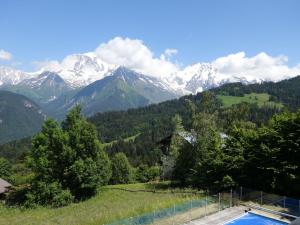 une piscine avec des montagnes en arrière-plan dans l'établissement Chalet L'Epachat by Interhome, à Mémontel