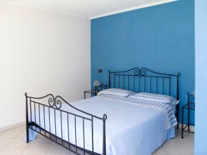 a blue bedroom with a bed with a blue wall at Apartment Serena - LMZ180 by Interhome in Riva
