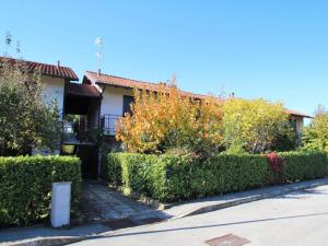 una casa con setos verdes frente a una calle en Apartment Red Sunset by Interhome, en  Monvalle 