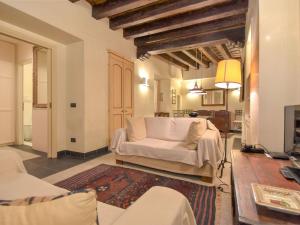 a living room with a white couch and a tv at Apartment Sotoportego Venier by Interhome in Venice