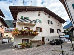 ein Gebäude mit einem Balkon und Blumen darauf in der Unterkunft Apartment Garibaldi by Interhome in Predazzo