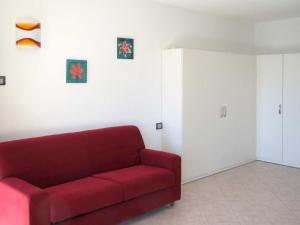 - un salon avec un canapé rouge et une armoire dans l'établissement Apartment Bellavista GRV391 by Interhome, à Consiglio di Rumo