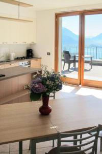 une cuisine avec une table et un vase de fleurs. dans l'établissement Apartment Bellavista GRV391 by Interhome, à Consiglio di Rumo