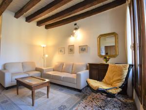 un soggiorno con divano, tavolo e specchio di Apartment Al Foghèr by Interhome a Venezia