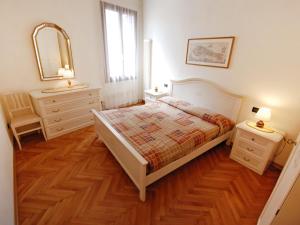 1 dormitorio con cama, tocador y espejo en Apartment Al Foghèr by Interhome, en Venecia