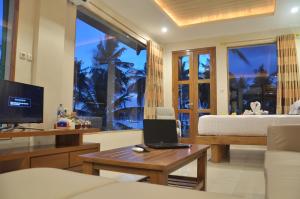 a living room with a bed and a laptop on a table at Crystal Beach Bali in Candidasa