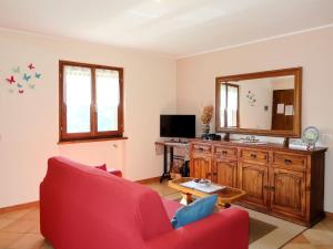 un soggiorno con divano rosso e specchio di Holiday Home Quang - GZO200 by Interhome a Garzeno