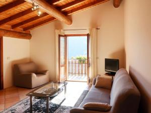a living room with a couch and a television at Holiday Home Quang by Interhome in Garzeno