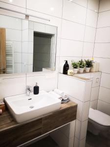 La salle de bains blanche est pourvue d'un lavabo et d'un miroir. dans l'établissement APARTMENT WALD - im Skigebiet Gerlitzen & Ossiacher See, à Bodensdorf
