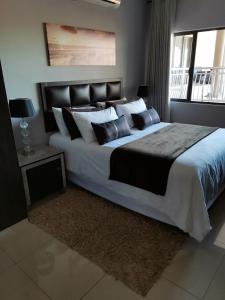 Un dormitorio con una cama grande y una ventana en Condo Villas, en Durban
