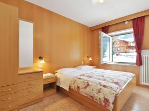 1 dormitorio con cama y ventana en Apartment Cincelli - Latemar by Interhome, en Pozza di Fassa