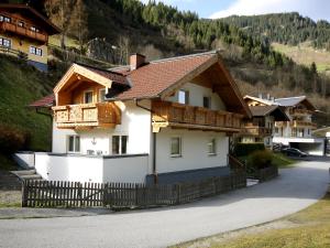 a white house with a brown roof at Apartment Haus Toferer by Interhome in Grossarl