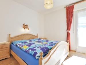 ein Schlafzimmer mit einem Bett mit einer Steppdecke darauf in der Unterkunft Apartment Ghetta by Interhome in Vigo di Fassa