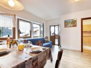 a dining room and living room with a table and chairs at Apartment Bernard-1 by Interhome in Campestrin