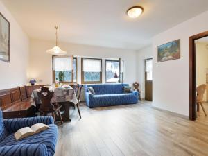 uma sala de estar com um sofá azul e uma mesa em Apartment Bernard-1 by Interhome em Campestrin