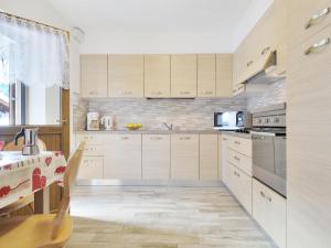 a kitchen with white cabinets and a table in it at Apartment Bernard-1 by Interhome in Campestrin +26 photos