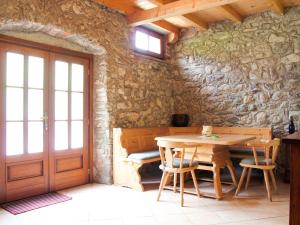 jadalnia ze stołem i kamienną ścianą w obiekcie Apartment La Tartufaia-6 by Interhome w Tremosine Sul Garda