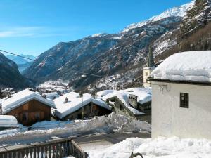 un pueblo cubierto de nieve con montañas en el fondo en Apartment Plen Solei by Interhome, en Valtournenche