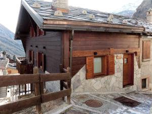 a wooden house with a fence in front of it at Apartment Plen Solei by Interhome in Valtournenche