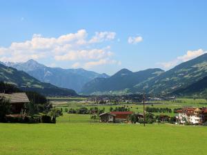 a green field with houses and mountains in the background at Apartment Fabian by Interhome in Ried im Zillertal