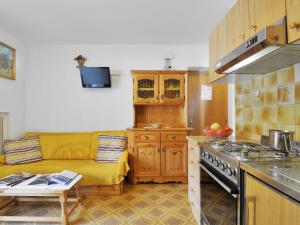 a kitchen with a couch and a stove at Apartment Maura-2 by Interhome in Pozza di Fassa