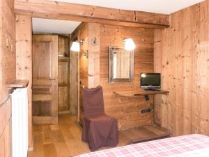 a bedroom with a bed and a desk and a television at Apartment La Tata by Interhome in Valtournenche +24 photos