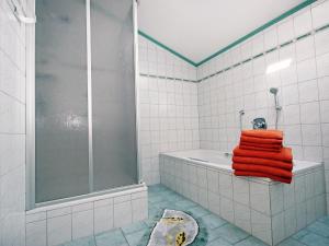 ein Badezimmer mit orangefarbenen Handtüchern auf der Badewanne in der Unterkunft Apartment Hundsbichler-1 by Interhome in Hippach