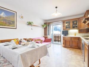 a kitchen and living room with a table with food on it at Apartment Florian Pia by Interhome in Pozza di Fassa