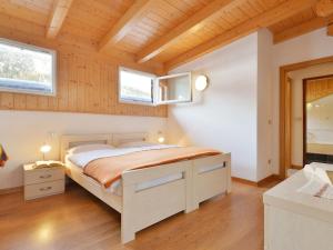 a bedroom with a bed and two windows at Apartment Florian Pia by Interhome in Pozza di Fassa