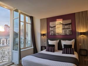 a hotel room with two beds and a large window at City Loft Apparthotel in Dijon
