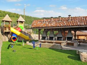 un parco giochi con scivolo sull'erba accanto a un edificio di Apartment Royal Gala by Interhome a Sanzeno
