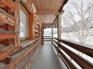 a balcony of a log cabin with a view of the mountains at Apartment Ardoney-1 by Interhome in Campitello