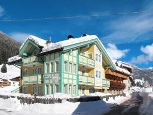 a large building with snow on the roof at Apartment Spinel by Interhome in Campitello