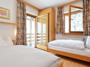 a bedroom with two beds and a window at Apartment Ardoney-1 by Interhome in Campitello