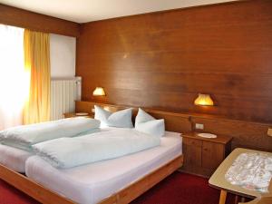 a bedroom with a large bed with a wooden wall at Apartment Haupthaus Schönblick by Interhome in San Valentino alla Muta