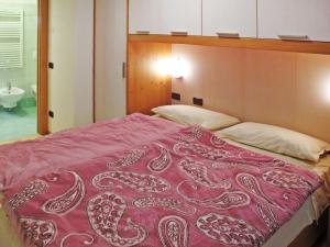 a bedroom with a bed with a red blanket at Apartment Giovanni - CPO359 by Interhome in Campitello