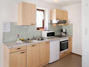 kuchnia ze zlewem i kuchenką mikrofalową w obiekcie Apartment Haupthaus Schönblick - SVH116 by Interhome w mieście San Valentino alla Muta