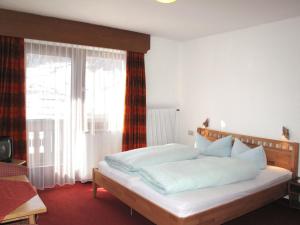 sypialnia z białym łóżkiem i dużym oknem w obiekcie Apartment Haupthaus Schönblick - SVH116 by Interhome w mieście San Valentino alla Muta +34 zdjęcia