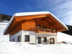 a house with a balcony in the snow at Apartment Spieglhof-2 by Interhome in Sarntal