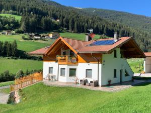 une maison avec un toit solaire sur un champ vert dans l'établissement Apartment Spieglhof-2 by Interhome, à Sarentino