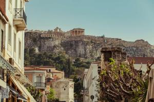 uma cidade com uma montanha ao fundo com edifícios em The Residence Aiolou Hotel & Spa em Atenas