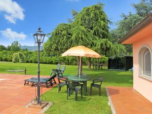 eine Terrasse mit einem Tisch, Stühlen und einem Sonnenschirm in der Unterkunft Holiday Home Teresa by Interhome in Piaggiori